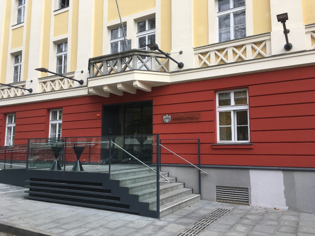 Historische Gebäudefassade mit Holzfenstern und repräsentativem Eingang.